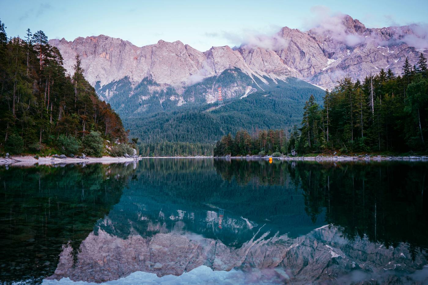 The still Eibsee reflecting the Zugspitze massif at dusk, forest on both shores
