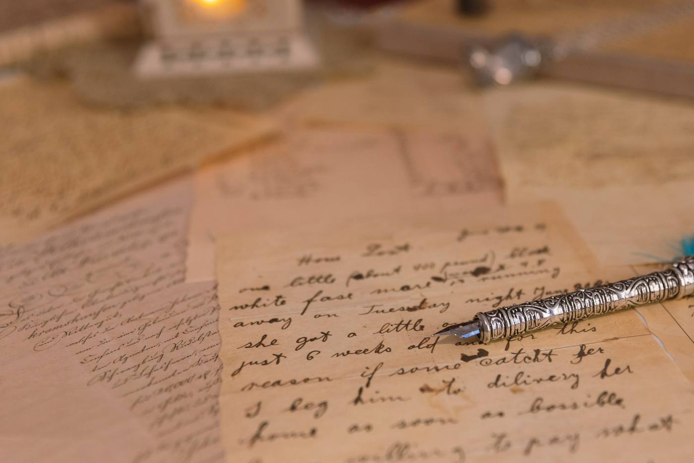 Old handwritten letters with a metal dip pen and a candle lantern