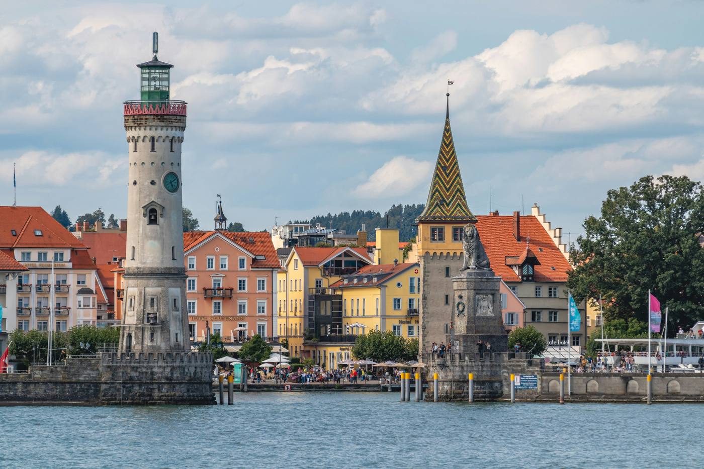 Lindau harbour entrance seen from the lake: the lighthouse on the left, the Bavarian lion on the right, colourful houses behind